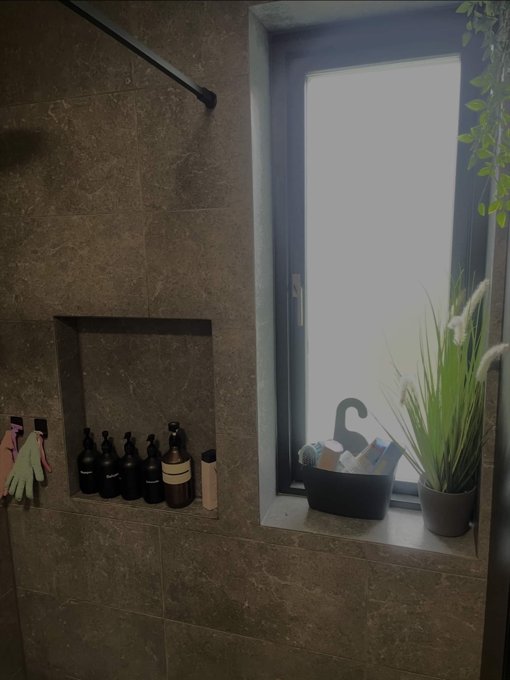 Indbygget hylde i bruseniche med brune, marmorerede fliser