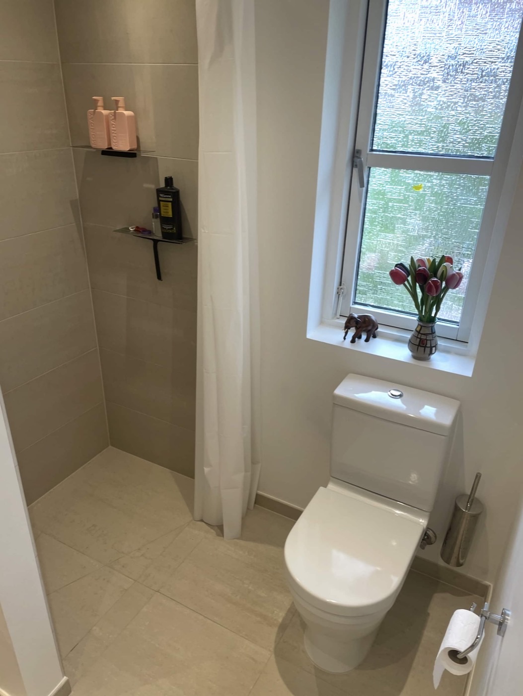 Lyst badeværelse i Taastrup med bruseniche i beige fliser og indbygget hylde
